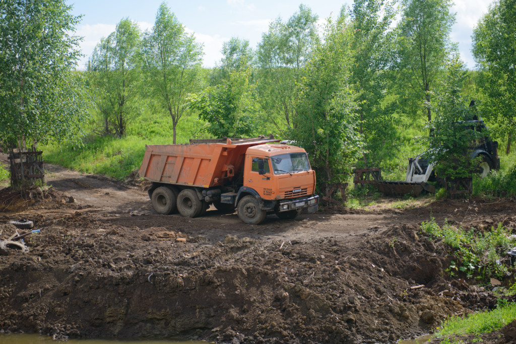 June 19, 2021: Construction equipment, a dump truck, an excavator and a tractor dig the ground for a reservoir. The village of Syatrakasy. Chuvashia. Russia.